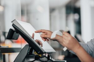 Photo by Simon Kadula a person is using a pos machine in a store